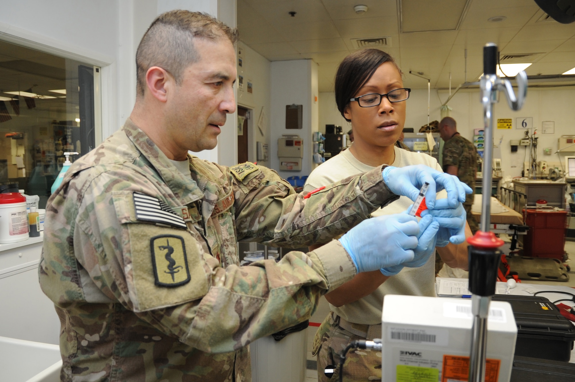 Maj. Fernando Santana, 455th Expeditionary Medical Support Squadron pharmacy flight commander deployed from Joint Base San Antonio, Texas, and Master Sgt. Tammy Robinson, 455th EMDSS pharmacy flight chief deployed from Maxwell Air Force Base, Ala., label a syringe for use on a trauma patient being treated at the Craig Joint Theater Hospital on Bagram Airfield, Afghanistan, April 23, 2013. The pharmacy flight provides medication support for more than 30 trauma cases each month. (U.S. Air Force photo/Staff Sgt. David Dobrydney)
