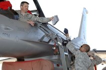 ELLINGTON FIELD, Texas - Tech. Sgt. Chris Hase takes a technical manual from Staff Sgt. Christopher Boyd during a weapons download and functional test of an F-16 fighter during an Amalgam Mute inspection March 15. As well as inspecting a unit's ability to employ and control aircraft, North American Aerospace Defense Command Inspector General personnel also inspect and grade the unit on their ability to maintain and reconstitute their aircraft following a mission. Hase and Boyd are aircraft armament systems specialists with the 138th Fighter Wing, Detachment 1. 

(U.S. Air Force photo by Tech. Sgt. Thomas J. Doscher) 

