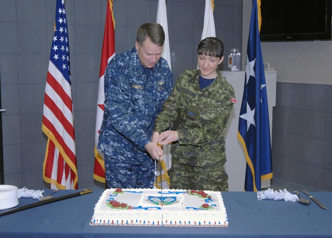 PETERSON AIR FORCE BASE, Colo. - Navy Adm. James Winnefeld, North American Aerospace Defense Command and U.S. Northern Command commander, and Canadian Forces Cpl. Danette Weyh, NORAD Operations Directorate air domain technician, cut the NORAD birthday cake during the NORAD Agreement anniversary celebration May 12 in NORAD headquarters. The original NORAD agreement was signed May 12, 1958. 

(U.S. Air Force photo by Tech. Sgt. Thomas J. Doscher) 

