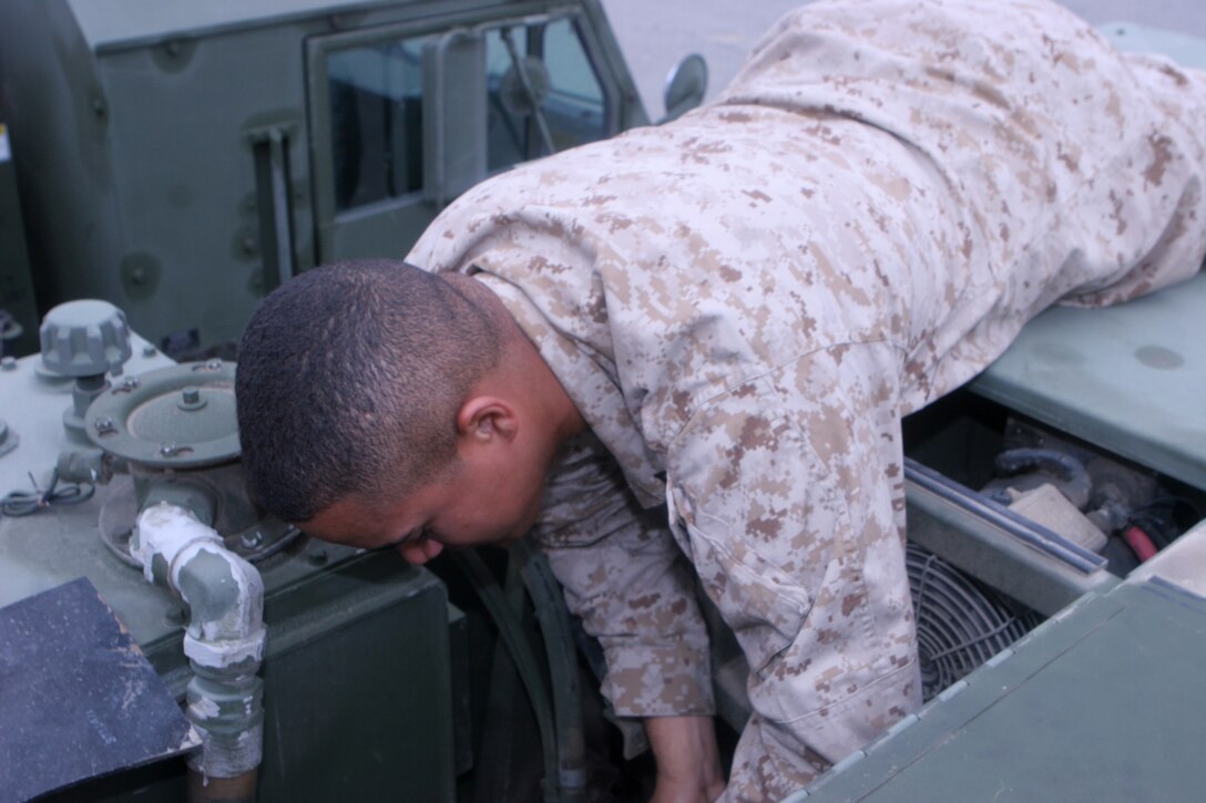 Lance Cpl. Robinson Ramos, a motor transportation operator with Motor Transport Company, Combat Logistics Battalion 1, Combat Logistics Regiment 1, 1st Marine Logistics Group, checks the oil of a Logistics Vehicle System at Camp Pendleton, Calif., April 24, 2013. Combat Logistics Battalion 1 was named the 2012 Motor Transport Unit of the Year by the Marine Corps Motor Transport Association.