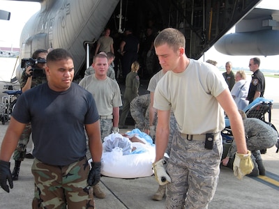 Litter patients are carried from a Texas Air National Guard C-130 Hercules Aug. 31 to awaiting ambulances at Lackland Air Force Base in San Antonio following their aeromedical flight from Beaumont, Texas. In the potential path of Hurricane Gustav's landfall, a multi-state aeromedical Air Guard team from Texas, Delaware, West Virginia, Oklahoma and Tennessee helped airlift at least 247 patients to safety Aug. 30-31.