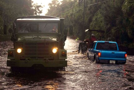 Members of the 2nd Battalion, 124th Infantry Regiment, make their way past a makeshift tow truck in a high-water vehicle as they search flooded roads and properties for people needing assistance or evacuation. The Florida National Guard assisted civilian agencies with nearly 500 Soldiers and Airmen supporting logistical operations and high-water vehicle rescues across central and northern Florida after Tropical Storm Fay struck in late August.