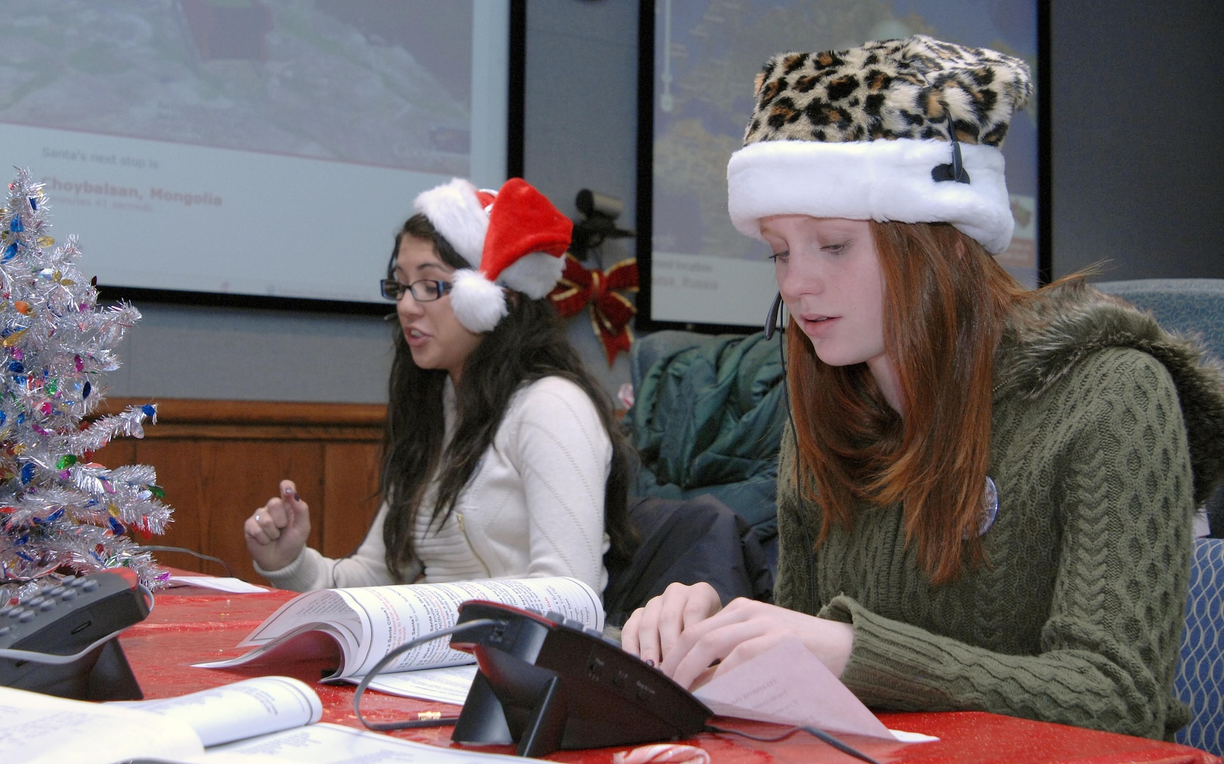 PETERSON AIR FORCE BASE, Colo. - Naomi Bishop, 17, and Reilly Rogers, 13, take calls at the NORAD Tracks Santa Operations Center on Peterson Air Force Base Dec. 24. More than 1,200 volunteers in the 23-hour NORAD Tracks Santa operations center answered nearly 102,000 calls this year from children looking for Santa Claus (up over 20,000 from 2010). Volunteers ranged from Peterson AFB family members volunteering their time to First Lady Michelle Obama, who for the second year, answered NORAD Tracks Santa calls from Hawaii. (U.S. Air Force photo by Tech. Sgt. Thomas J. Doscher)