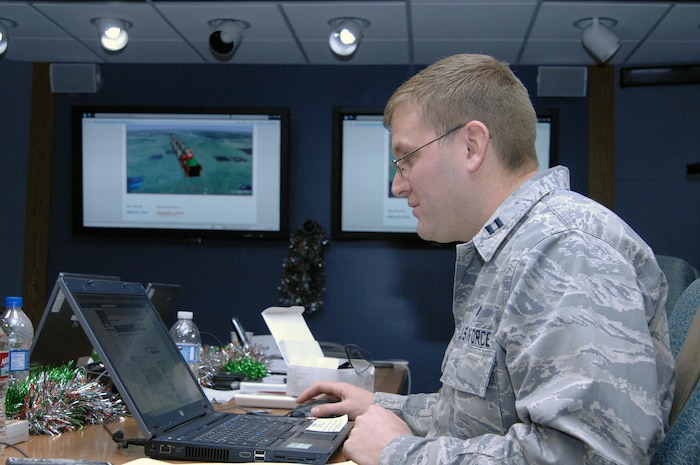PETERSON AIR FORCE BASE, Colo. - Capt. Dustin Hart, NORAD and USNORTHCOM NORAD Tracks Santa social media volunteer, looks over Facebook comments on the NORAD Tracks Santa Facebook page Dec. 24, 2011. Volunteers monitored E-mails, Facebook, Twitter, YouTube and Google+ posts and posted Santa's location as the night progressed. (U.S. Air Force photo by Tech. Sgt. Thomas J. Doscher)