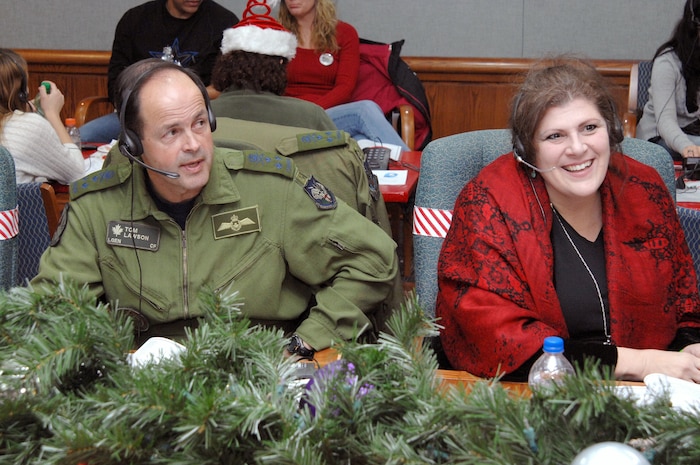 PETERSON AIR FORCE BASE, Colo. - Canadian Forces Lt.-Gen. Tom Lawson, North American Aerospace Defense Command deputy commander and NORAD Tracks Santa volunteer "Christmas" Karol Vanderploeg, take calls from children at the NTS Operations Center Dec. 24, 2011. Volunteers answered nearly 102,000 calls this year from children looking for Santa Claus, up over 20,000 from 2010 (U.S. Air Force photo by Tech. Sgt. Thomas J. Doscher)