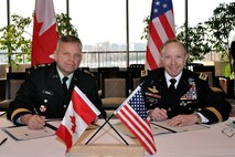 OTTAWA - Canadian Forces Lieutenant-General Walter Semianiw, Canada Command commander (left) and Army Gen. Charles Jacoby, Jr., North American Aerospace Defense Command and U.S. Northern Command commander, sign military to military plans in Ottawa, Jan. 25, to enhance defense cooperation between Canada and the United States should the governments require each other's assistance. The documents signed were the Civil Assistance Plan, the Combined Defence Plan and an Information Sharing Memorandum of Understanding. Jacoby signed the CAP and the CDP in his capacity as the commander of USNORTHCOM and the MOU as the commander of NORAD and USNORTHCOM. The signings followed the 228th meeting of the Permanent Joint Board on Defence in Ottawa. 

(Canadian Forces photo by Cpl. Kevin Sauvé) 

