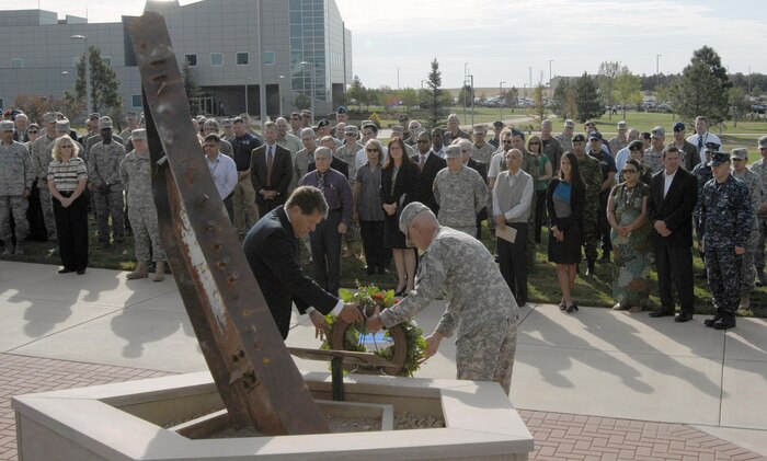PETERSON AIR FORCE BASE, Colo. - Members of NORAD and USNORTHCOM watch as Don Addy, Chairman of the Colorado 30 Group, and Army Maj. Gen. Charles Luckey, NORAD and USNORTHCOM Chief of Staff, lay a wreath at the headquarters 9/11 memorial Sept. 11, 2012. Every year, the NORAD and USNORTHCOM staff remember the victims of the 9/11 attacks with a ceremony commemorating their sacrifice. The memorial is comprised of three parts: The recovered steel beam pays respect to the lives lost in New York and points in the city’s direction. The five-sided planter honors those who died at the Pentagon, and the soil in the planter comes from Pennsylvania to pay respect to the people who died on Flight 93, which crashed in Shanksville, Penn. (U.S. Air Force photo by Michael Kucharek)
