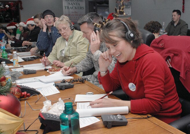 PETERSON AIR FORCE BASE, Colo. - Jennifer Eckels, first time NORAD Tracks Santa volunteer, takes calls at the NORAD Tracks Santa Operations Center. One of the calls Eckels received was from a little boy in Missouri who recently lost his sister. He wanted to know when Santa delivers presents to Heaven. Eckels told him that children in Heaven get their presents first. (US. Air Force photo by Tech. Sgt. Thomas J. Doscher)