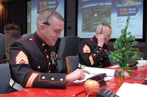 PETERSON AIR FORCE BASE, Colo. - Marine Staff Sgts. Hugh Wood and Randall Ayers, NORAD and USNORTHCOM, take calls at the NORAD Tracks Santa Operations Center Dec. 24, 2012. Wood and Ayers came to the operations center to collect toys for the Marine Corps' Toys for Tots program and took a break to participate in NORAD Tracks Santa. (U.S. Air Force photo by Tech. Sgt. Thomas J. Doscher)