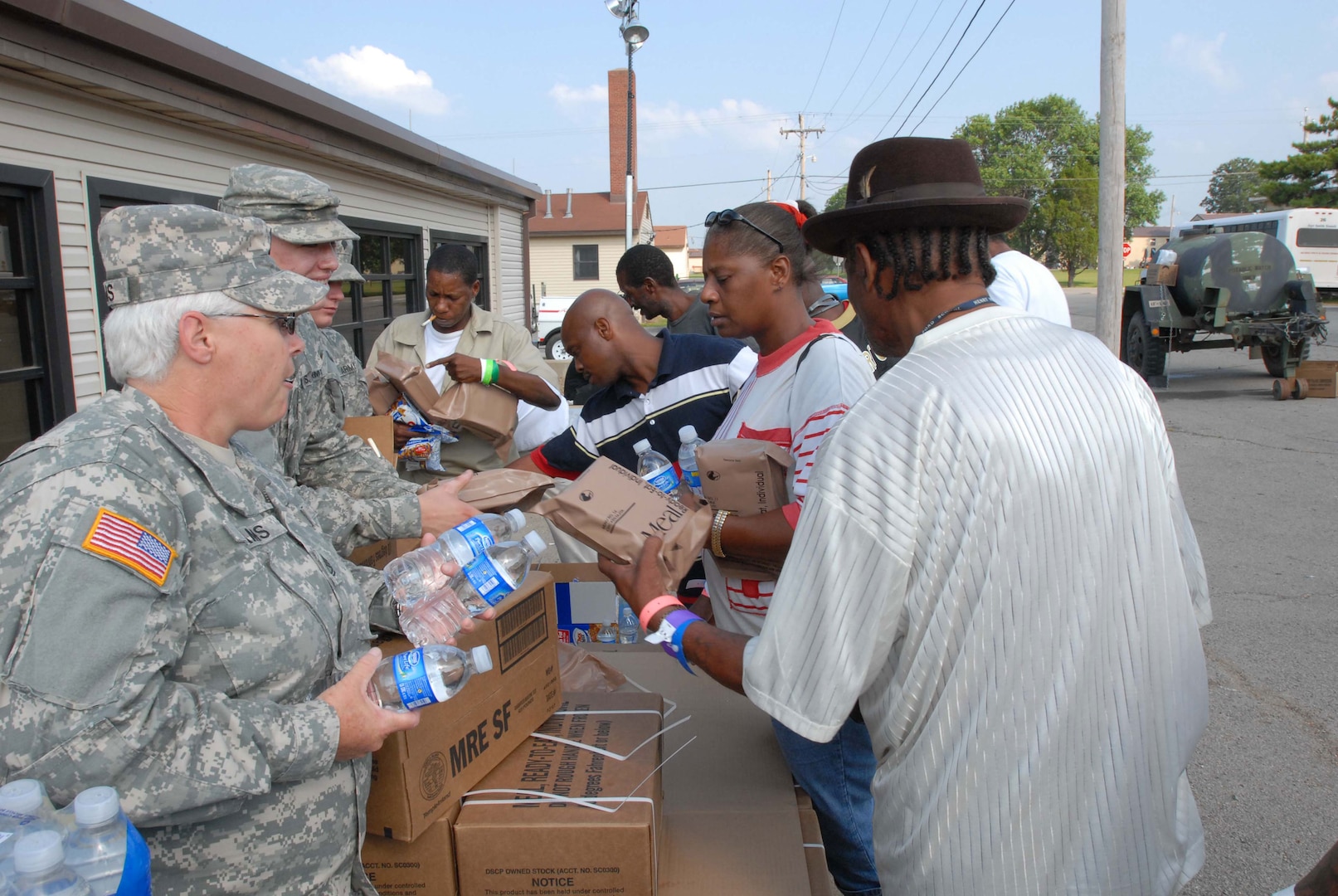 Members of the Arkansas Army National Guard's 142nd Fires Brigade hand out water and packaged military meals (MREs -Meals Ready to Eat) to individuals at Fort Chaffee who sought shelter from Hurricane Gustav. The World War II era post is housing over 2,300 displaced citizens while the Salvation Army is on hand at Fort Chaffee to take the lead role in feeding the evacuees. Fort Chaffee processed over 10,000 evacuees in the aftermath of Hurricane Katrina three years ago.