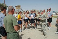 Camp Blackhorse run organizer Sgt. John O'Dougherty from Valley Stream, Long Island and a member of the Fighting 69th presents certificates to the run participants at the end of the event.