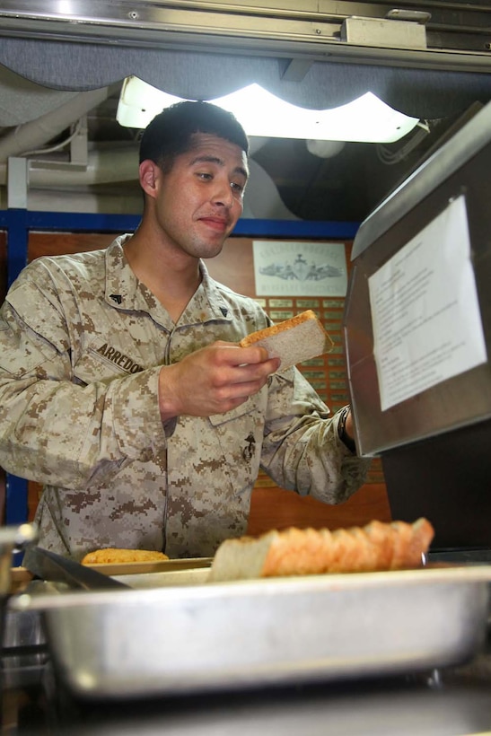 130425-M-VZ265-010 USS RUSHMORE (April 25, 2013) Corporal Francisco A. Arredondo, motor transportation operator, 2nd Platoon, Battery B, Battalion Landing Team 3/5, 15th Marine Expeditionary Unit, toasts bread on the mess deck of USS Rushmore, April 25. The 15th MEU is comprised of approximately 2,400 Marines and sailors and is deployed as part of the Peleliu Amphibious Ready Group. Together, they provide a forward-deployed, flexible sea-based Marine Air Ground Task Force capable of conducting a wide variety of operations ranging from humanitarian aid to combat. Arredondo, 21, is from Odessa, Texas. (U.S. Marine Corps photo by Cpl. Timothy Childers/Released)
