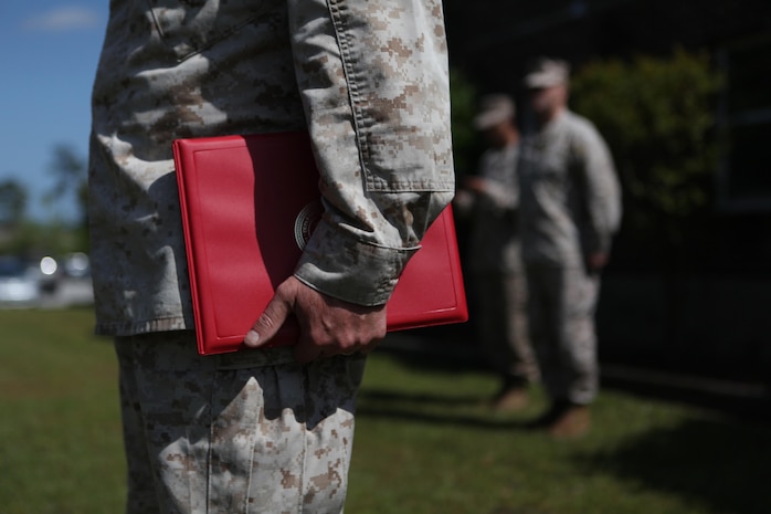 Sgt. Maj. George W. Young Jr., 2nd Marine Logistics Group’s sergeant major, holds the citation for Navy Lt. Wilfredo L. Lucas, the operations officer of 2nd Medical Battalion, Combat Logistics Regiment 25, 2nd MLG, during a Bronze Star Medal ceremony held for Lucas aboard Camp Lejeune, N.C., April, 24, 2013. Lucas received the award for lifesaving changes he developed with Afghan National Army doctors.