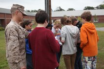Sgt. Joshua A. Oakes (left), a tactics readiness and training instructor with Combat Logistics Regiment 27, 2nd Marine Logistics Group, teaches students how to find specific locations on a map during a land navigation class at Brewster Middle School aboard Camp Lejeune, N.C., April 25, 2013. The class was part of a larger plan to reduce reliance on more advanced technology that does not always work properly.