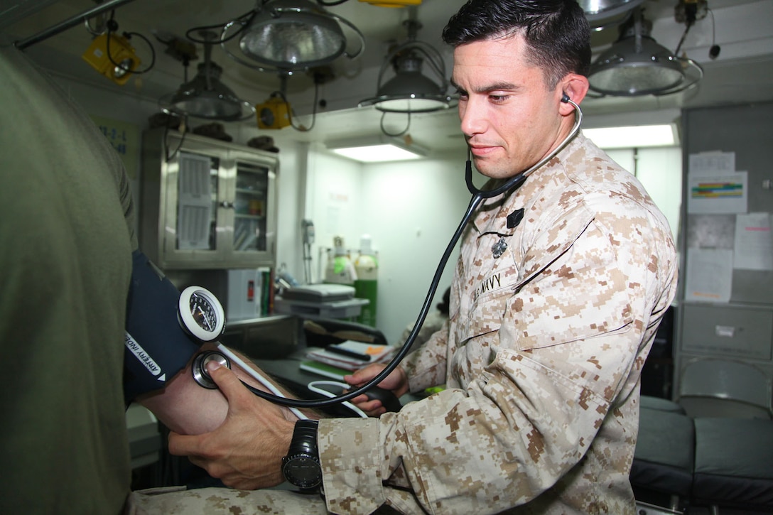 130424-M-VZ265-009 USS RUSHMORE (April 24, 2013) Petty Officer 2nd Class Marcel O. Fucci, corpsman, Health Services Detachment, Combat Logistics Battalion 15, 15th Marine Expeditionary Unit, checks the blood-pressure of Master Gunnery Sgt. Jason Topp, operations chief, CLB-15, 15th MEU, in the medical department of USS Rushmore, April 24. Fucci, a 29-year-old native of Orlando, joined the Navy a week before the events on Sept. 11, 2001. Working as a Corpsman for more than 11 years, he has learned what it means to help others. The 15th MEU is comprised of approximately 2,400 Marines and sailors and is deployed as part of the Peleliu Amphibious Ready Group. Together, they provide a forward-deployed, flexible sea-based Marine Air Ground Task Force capable of conducting a wide variety of operations ranging from humanitarian aid to combat. (U.S. Marine Corps photo by Cpl. Timothy Childers/Released)