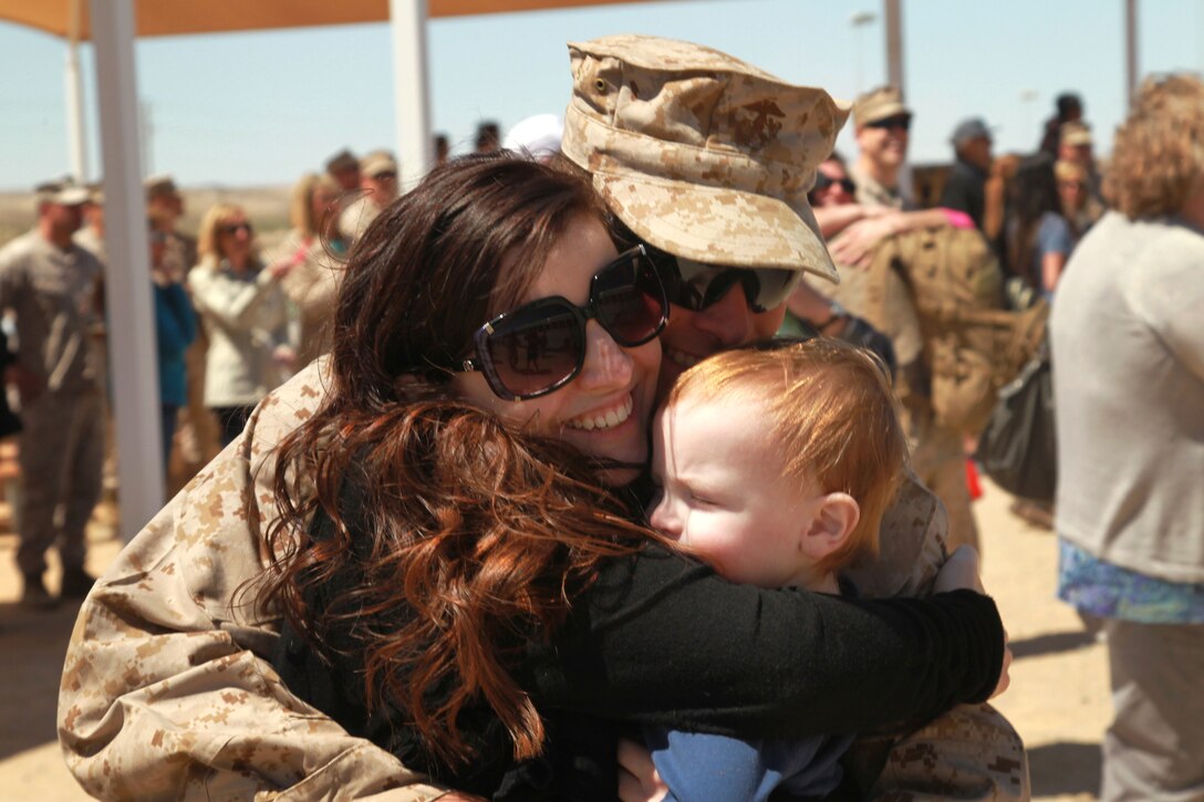 Lance Cpl. Tristan Tiller, radio operator, Headquarters and Service Company, 2nd Battalion, 7th Marine Regiment, surprises his wife, Kylie, and son Kysan, 1, during the battalion's homecoming at Del Valle Field Tuesday.