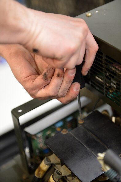 Senior Airman Mathew Vanderwater, 62nd Maintenance Squadron Aerospace Ground Equipment technician, tightens a screw on a protective plate covering an electrical relay on a -86 diesel generator, April 26, 2013 at Joint Base Lewis-McChord, Wash. AGE technicians are trained in a wide variety of maintenance disciplines, to include electrical theory, diesel and turbine engine maintenance, and hydraulic systems. (U.S. Air Force photo/Airman 1st Class Jacob Jimenez)