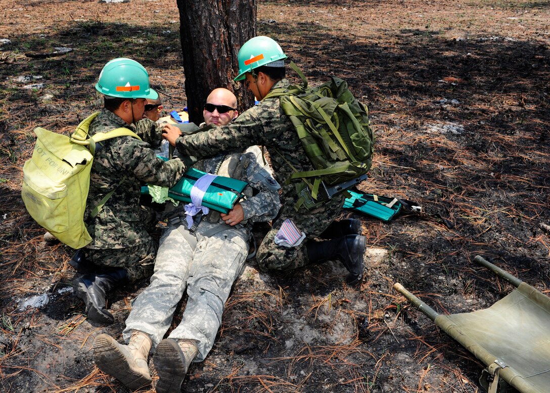 Honduran military medics bandage Army Staff Sgt. David Simpson, a simulated patient for evacuation during an Isolated Personal Recovery Exercise, April 25. The exercise is designed to test the capabilities of the JSF and Hondurans ability to secure the isolated personnel and for the medics to asses and extract the injured. The continued joint training hones JTF-B and the Honduran military skills for a real world emergency. (Air Force photo by Staff Sgt. Eric Donner)