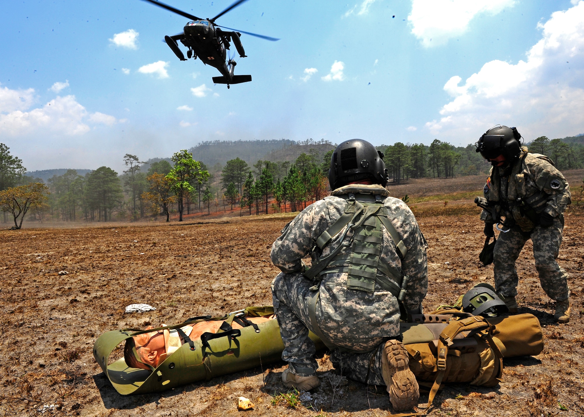 Army Sgt. Jason Dudley, Flight Medic and Army Staff Sgt. Jennifer Norris, Flight Medic prepare to hoist a simulated patient into a waiting 1st Battalion 228th Aviation Regiment UH-60 Blackhawk. Joint Task Force-Bravo’s Joint Security Force teamed up with the Honduran Air Force and Army to conduct an Isolated Personnel Recovery Exercise, April 25. The exercise is designed to test the capabilities of the JSF and Hondurans ability to secure the isolated personnel and for the medics to asses and extract the injured. The continued joint training hones JTF-B and the Honduran military skills for a real world emergency. (Air Force photo by Staff Sgt. Eric Donner)