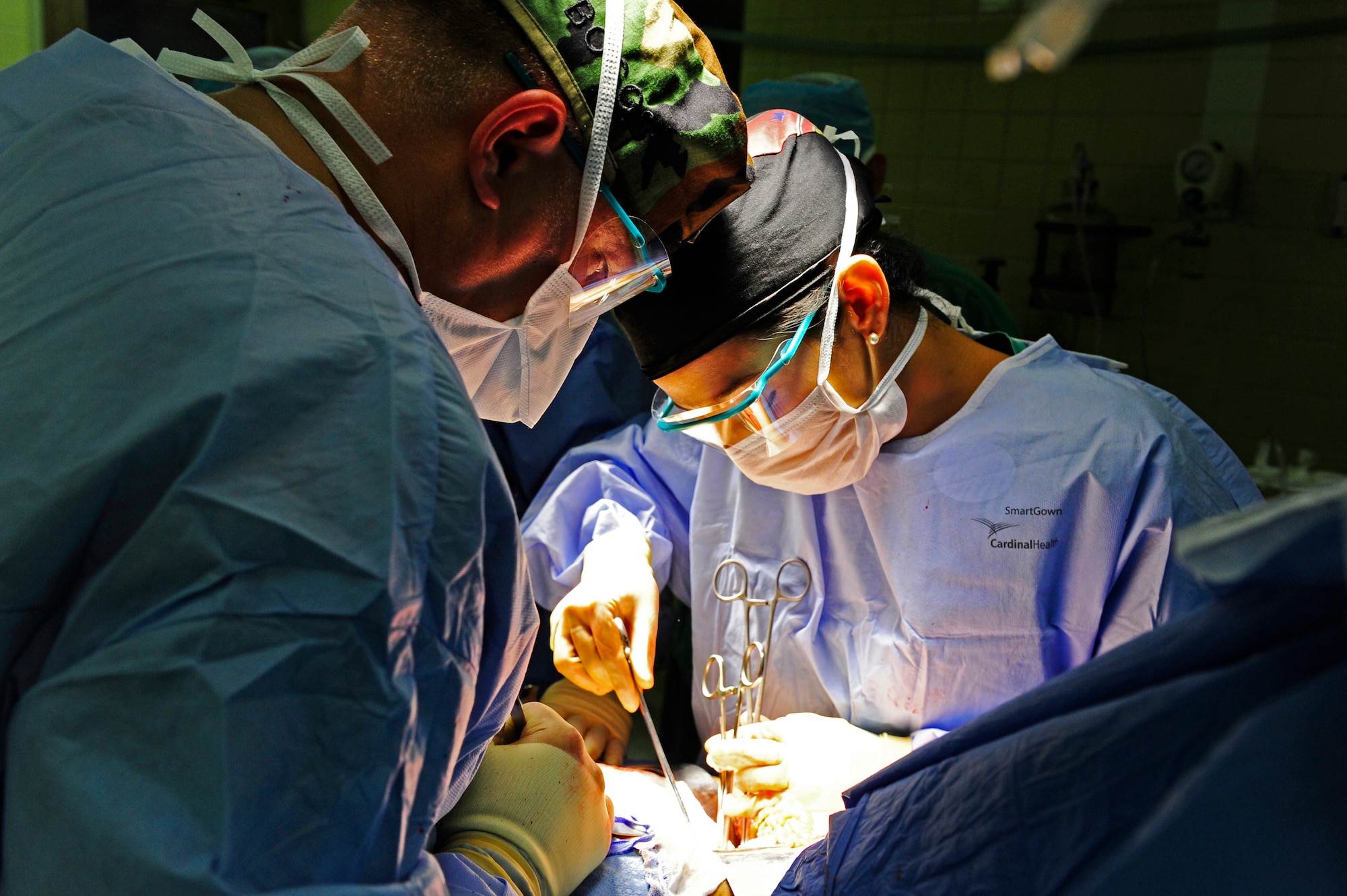 Army Maj. Charles Boggs, MST surgeon and Honduran Dr. Carolina Velez, third year surgery resident, perform surgery on a patient during a Surgical Medical Readiness Training exercise at Hospital Escuela in Tegucigalpa, April 23. (Air Force photo by Staff Sgt. Eric Donner)