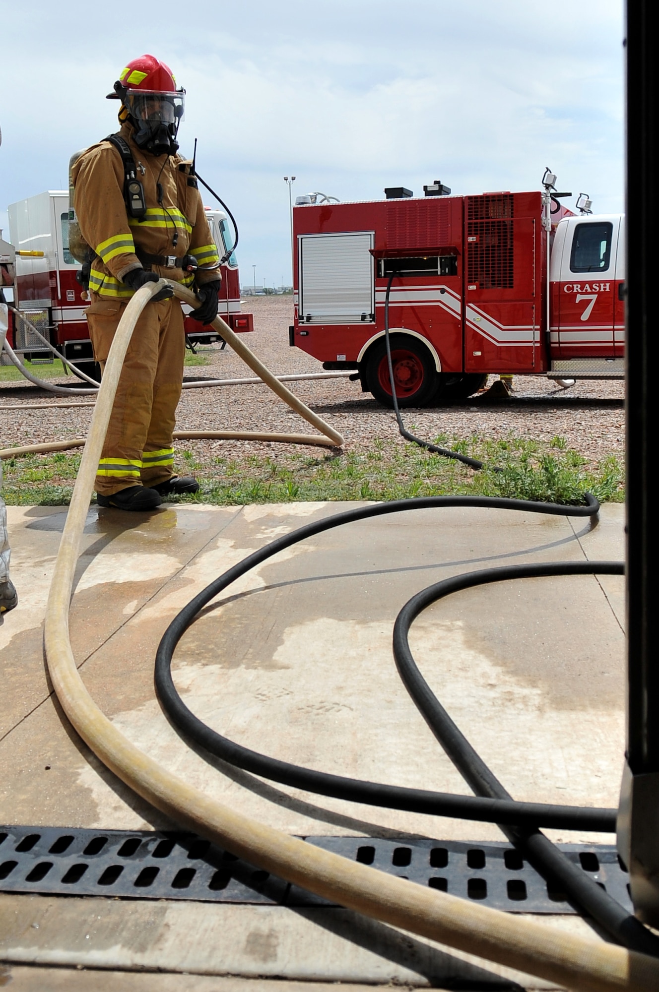 ALTUS AIR FORCE BASE, Okla. – A firefighter from the 97th Civil Engineer Squadron fire department secures a hose during high-pressure firefighting training at the burn pit April 25. The training incorporates new techniques that reduce the amount of water, fuel and manpower needed to suppress fires. (U.S. Air Force photo by Senior Airman Dillon Davis/Released)