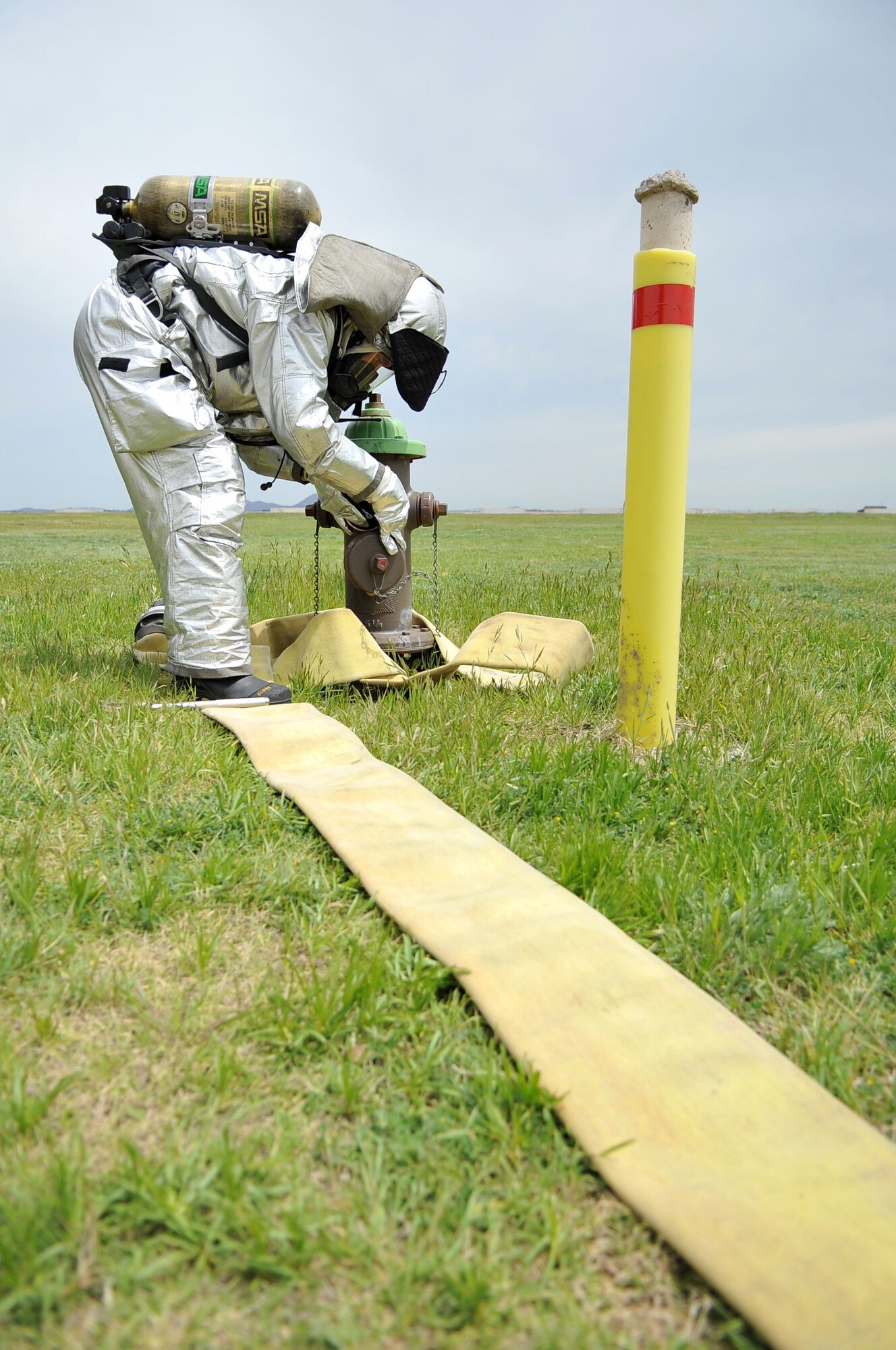 ALTUS AIR FORCE BASE, Okla. – A firefighter from the 97th Civil Engineer Squadron fire department attaches a hose to a fire hydrant during high-pressure firefighting training at the burn pit April 25. The high-pressure firefighting is a new technique that reduces costs and improves firefighting efficiency. (U.S. Air Force photo by Senior Airman Dillon Davis/Released)