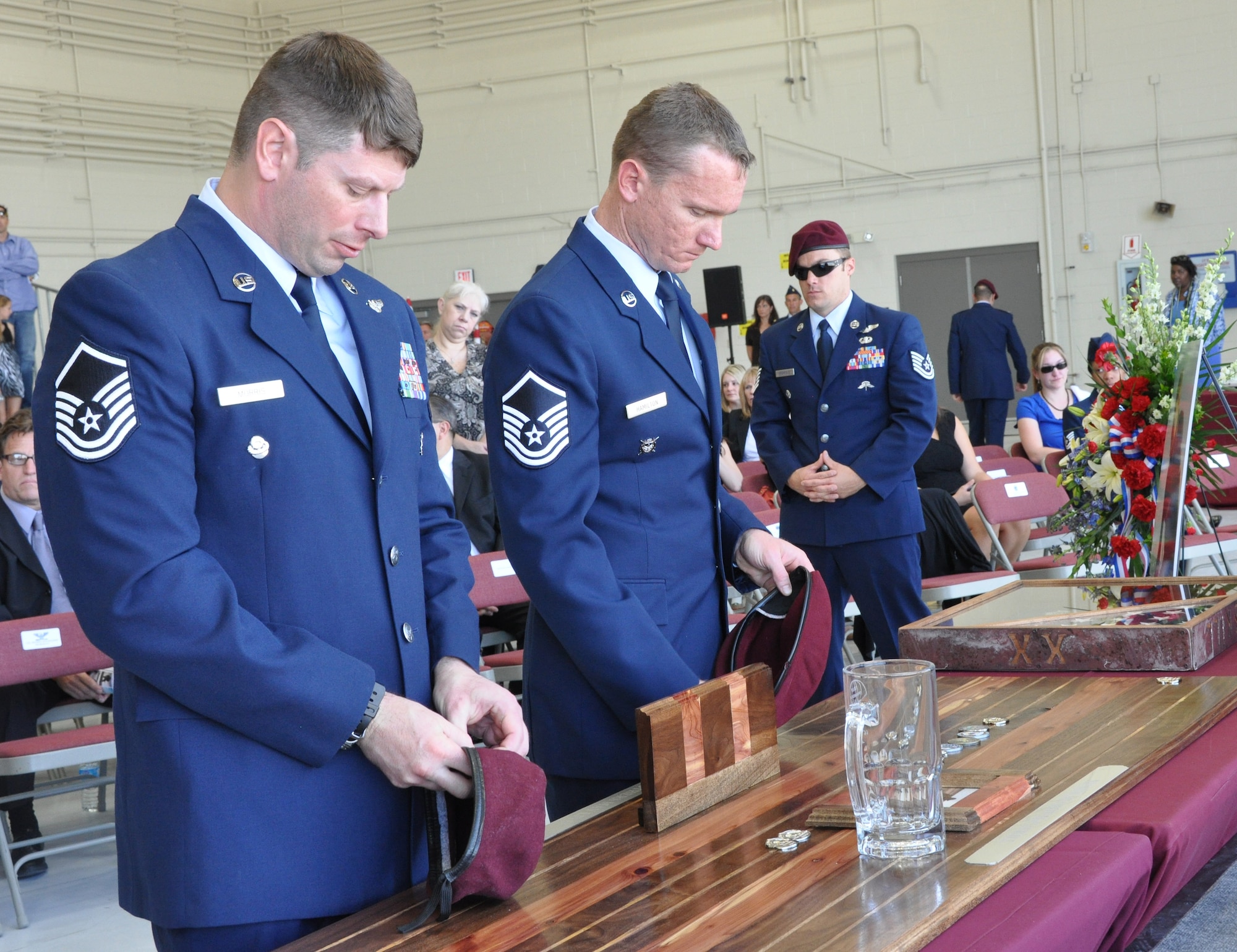 306th Rescue Squadron pararescue Airmen remove their flash from their beret to pound onto a board as final sign of respect for Chief Master Sgt. Nicholas McCaskill who was killed in Afghanistan while he was performing his civilian job as a security contractor, April 6, 2013. The 306th RQS held a memorial ceremony to honor the life and more than 20 year U.S. Air Force career of McCaskill. (U.S. Air Force Photo/ Staff Sgt. Sarah Pullen)  