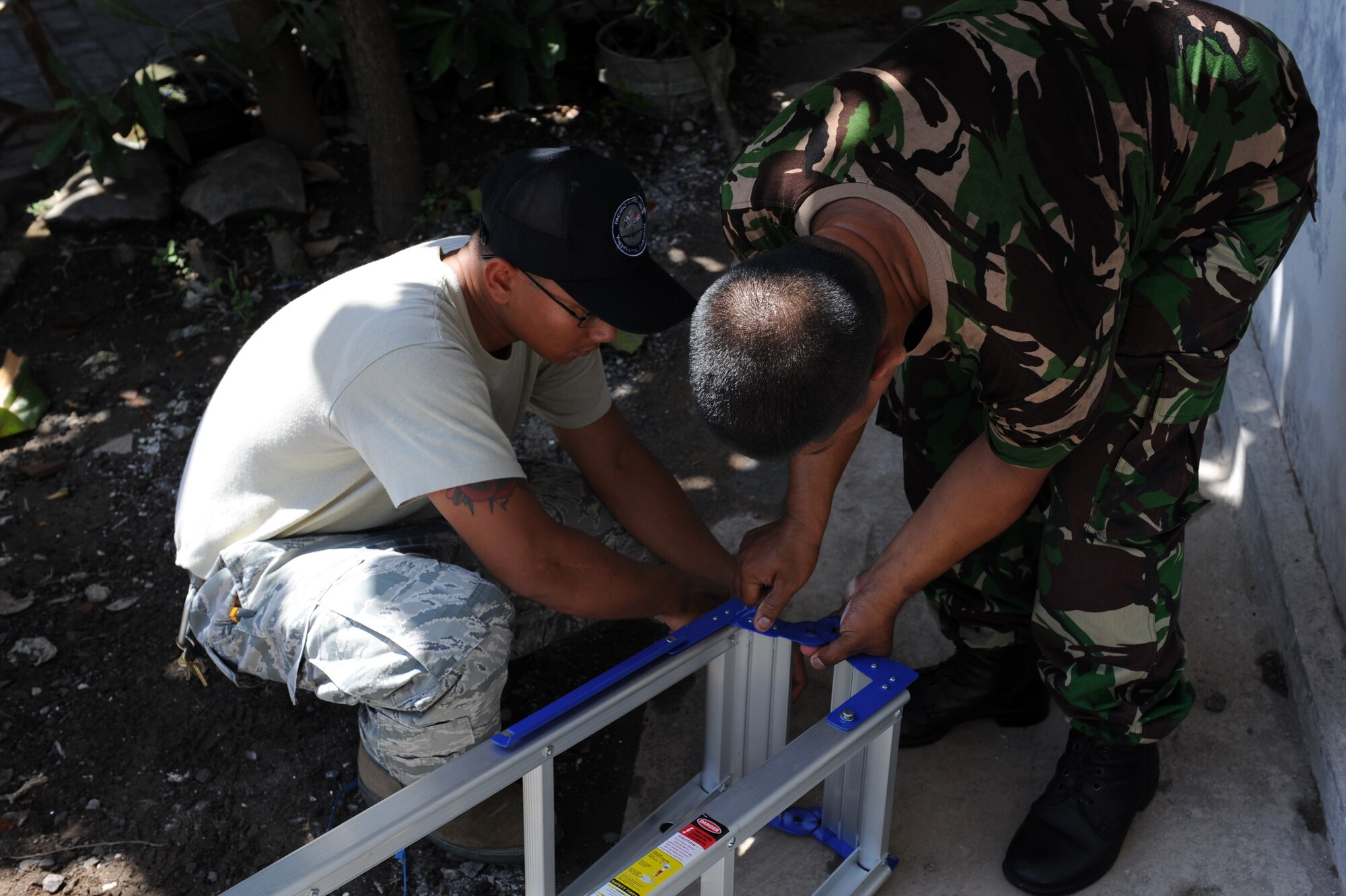 U.S. Air Force Staff Sgt. Endro Accettola, left, electrical systems journeyman, puts a ladder together with a member of the Indonesian Armed Forces during Pacific Angel 13-2 at Yogyakarta, Republic of Indonesia. Accettola is from Joint Base Pearl Harbor Hickham, Hawaii. PACANGEL is a joint and combined humanitarian assistance exercise held in various countries several times a year and includes medical, dental, optometry, engineering programs and various subject-matter expert exchanges. (U.S. Air Force photo by Airman 1st Class Kia Atkins)
