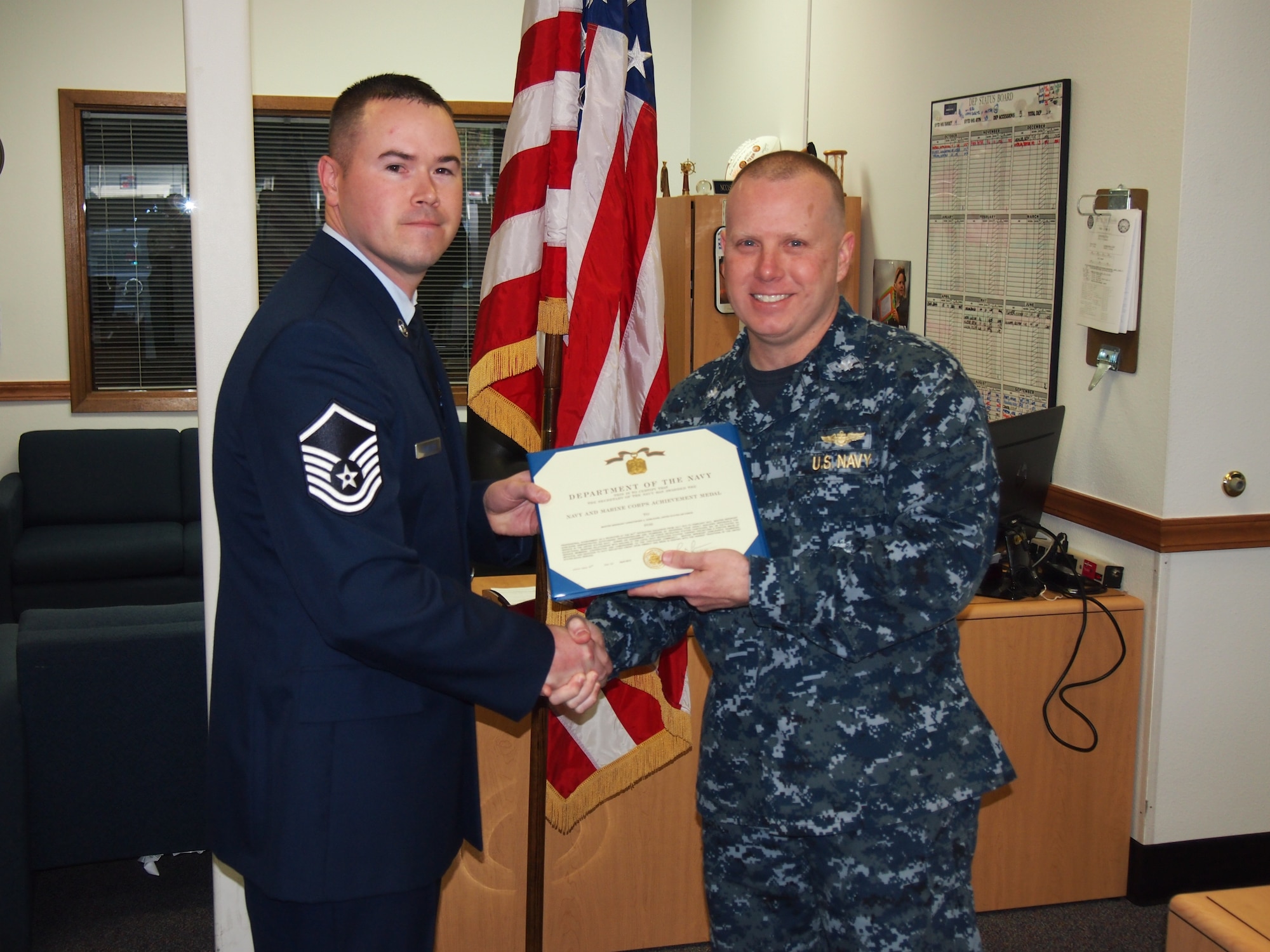 In a case of joint recruiting at its finest, Master Sgt. Christopher Dowlearn was presented with a Navy Achievement Medal April 17 by Cmdr. Ronnie Candiloro, commanding officer of the Navy Recruiting District in Portland, Ore. Dowlearn, of the 361st Recruiting Squadron, sent four disqualified Air Force applicants to the Navy recruiting office; all four qualified and entered the Navy’s Delayed Enlistment Program. (U.S. Air Force photo)