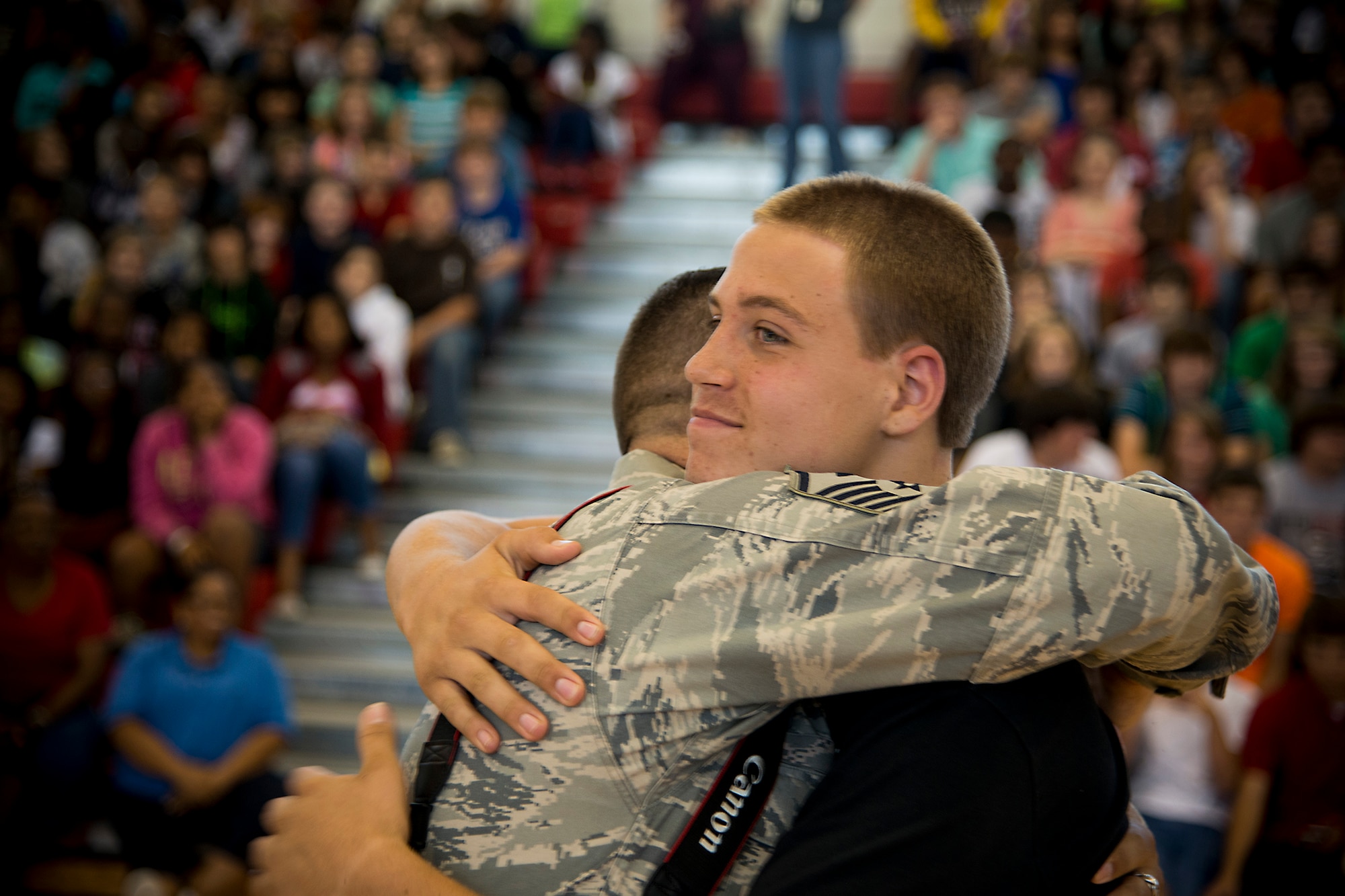 U.S. Air Force Master Sgt. John Lamp, 23d Component Maintenance Squadron first sergeant, hugs his son, Ian Lamp, April 26, 2013, at Pine Grove Middle School, Valdosta, Ga. Lamp said he was proud of his son for donating his hair to Locks of Love and for helping raise money for cancer research. (U.S. Air Force photo by Staff Sgt. Jamal D. Sutter/Released) 