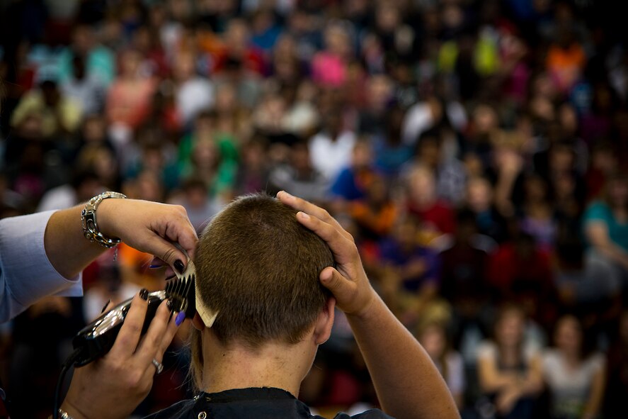 Ian Lamp, son of U.S. Air Force Master Sgt. John Lamp, 23d Component Maintenance Squadron first sergeant, feels his shaved head April 26, 2013, at Pine Grove Middle School, Valdosta, Ga. Lamp’s hair reached 22 inches in length before having it cut for donation to Locks of Love. (U.S. Air Force photo by Staff Sgt. Jamal D. Sutter/Released) 