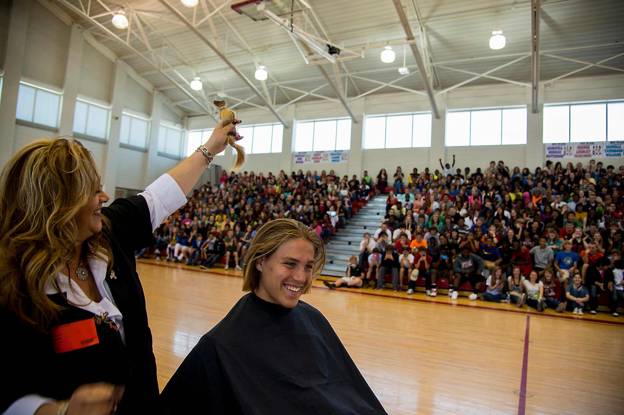 Lori Eccleston, professional beautician, holds up a 14-inch ponytail of hair from Ian Lamp, son of U.S. Air Force Master Sgt. John Lamp, 23d Component Maintenance Squadron first sergeant, April 26, 2013, at Pine Grove Middle School, Valdosta, Ga. More than 600 students watched as Eccleston cut Lamp’s hair for donation to Locks of Love. (U.S. Air Force photo by Staff Sgt. Jamal D. Sutter/Released)  
