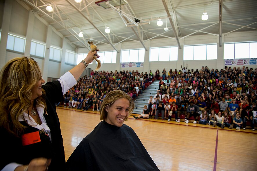 Lori Eccleston, professional beautician, holds up a 14-inch ponytail of hair from Ian Lamp, son of U.S. Air Force Master Sgt. John Lamp, 23d Component Maintenance Squadron first sergeant, April 26, 2013, at Pine Grove Middle School, Valdosta, Ga. More than 600 students watched as Eccleston cut Lamp’s hair for donation to Locks of Love. (U.S. Air Force photo by Staff Sgt. Jamal D. Sutter/Released)  