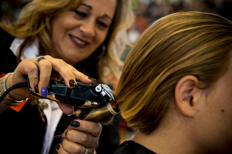 Lori Eccleston, professional beautician, cuts the hair of Ian Lamp, son of U.S. Air Force Master Sgt. John Lamp, 23d Component Maintenance Squadron first sergeant, April 26, 2013, at Pine Grove Middle School, Valdosta, Ga. Lamp donated his hair to Locks of Love and also helped raise $625 for Relay for Life. (U.S. Air Force photo by Staff Sgt. Jamal D. Sutter/Released)  