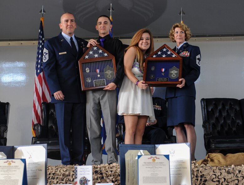 The Vallely family stands on stage to showcase a pair of shadow boxes at Moody Air Force Base, Ga., April 26, 2013. The Vallely’s gave the boxes to their children to show appreciation for the sacrifices they made throughout their careers. (U.S. Air Force photo by Airman Alexis Grotz/Released)