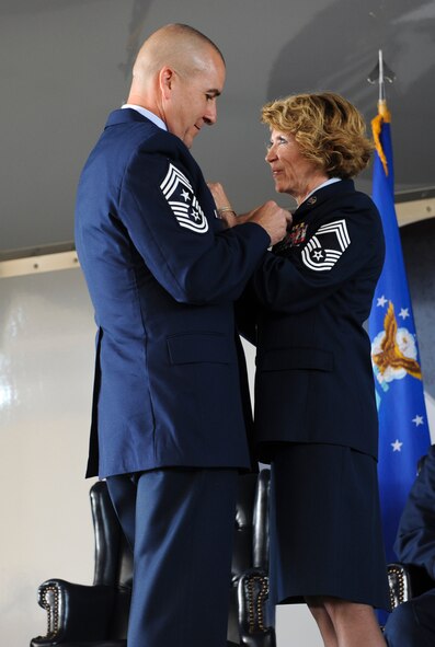 U.S. Air Force Chief Master Sgts. Dianna Vallely, 23d Medical Group chief enlisted manager, and Thomas Vallely, former 93rd Air Ground Operations Wing command chief master sergeant, attach each other’s retirement pins at Moody Air Force Base, Ga., April 26, 2013. They both served  more than 27 years. (U.S. Air Force photo by Airman Alexis Grotz/Released)