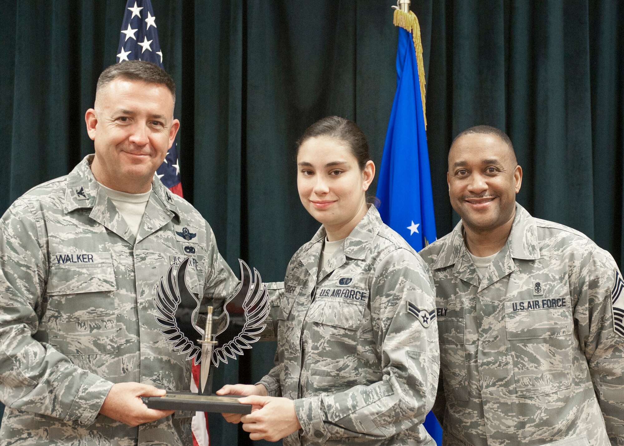 Colonel Craig Walker 27th Special Operations Wing Vice Commander, along with Chief Master Sergeant Marvin Neely present Airman 1st Class Stephanie Ruediger with the 2013 Volunteer of the Quarter award for first quarter April 26. Winners were selected based on outstanding accomplishments during the months of January through March. (U.S. Air Force photo/ Airman 1st Class Xavier Lockley)
