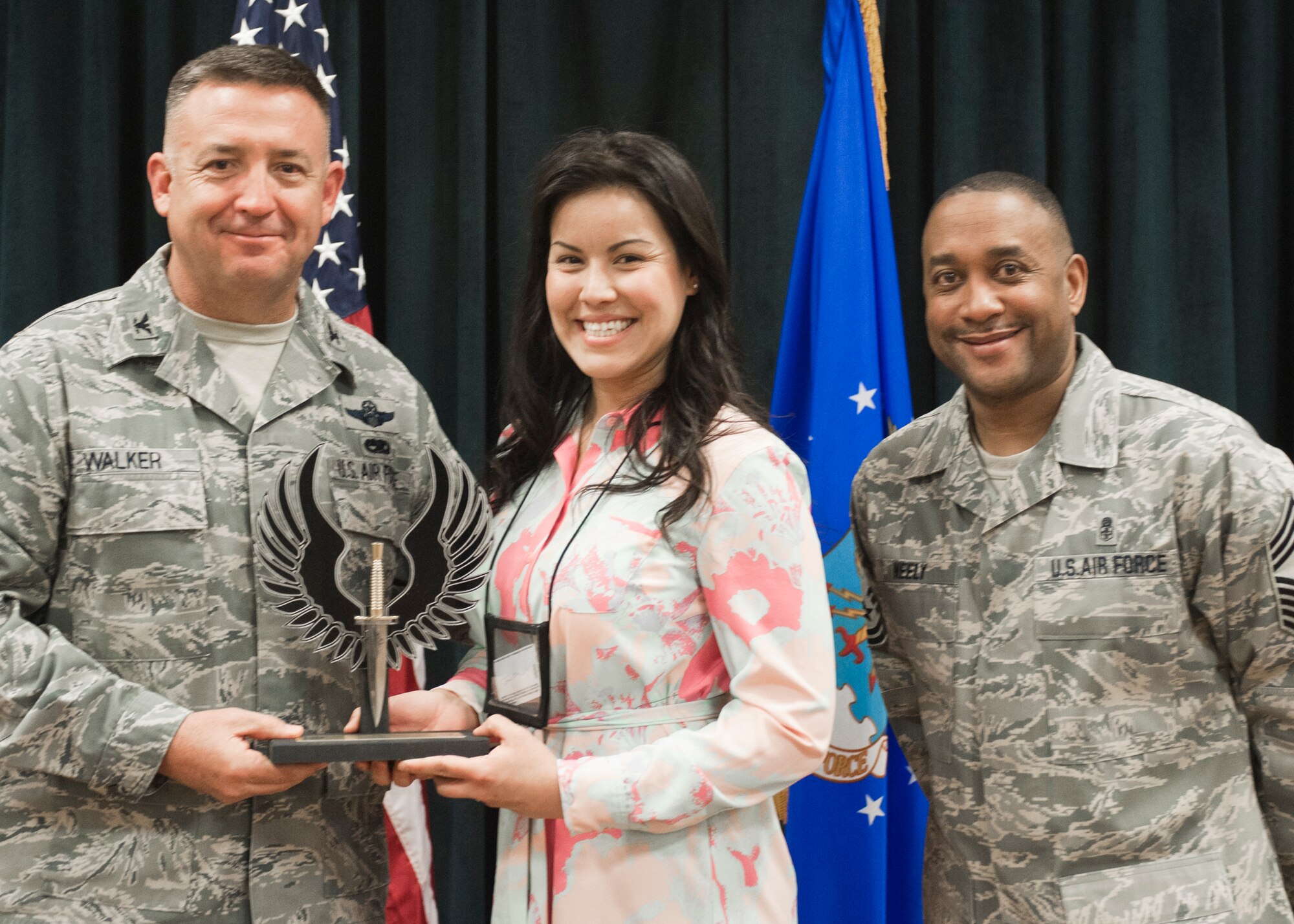 Colonel Craig Walker 27th Special Operations Wing Vice Commander, along with Chief Master Sergeant Marvin Neely present Mrs. Desiree Ann Montenegro with the 2013 Civilian category I of the Quarter award for first quarter April 26. Winners were selected based on outstanding accomplishments during the months of January through March. (U.S. Air Force photo/ Airman 1st Class Xavier Lockley)