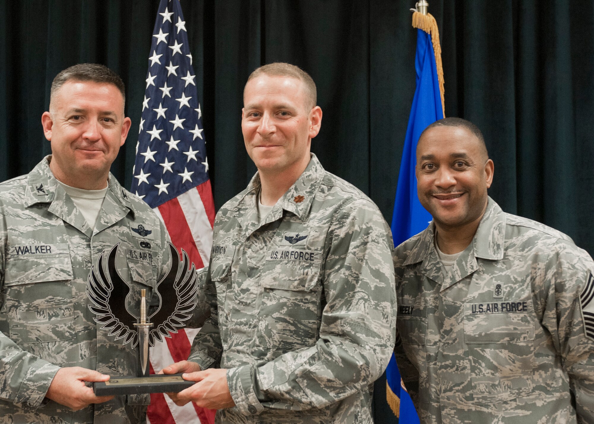 Colonel Craig Walker 27th Special Operations Wing Vice Commander, along with Chief Master Sergeant Marvin Neely present Maj. James Marion with the 2013 FGO of the Quarter award for first quarter April 26. Winners were selected based on outstanding accomplishments during the months of January through March. (U.S. Air Force photo/ Airman 1st Class Xavier Lockley)