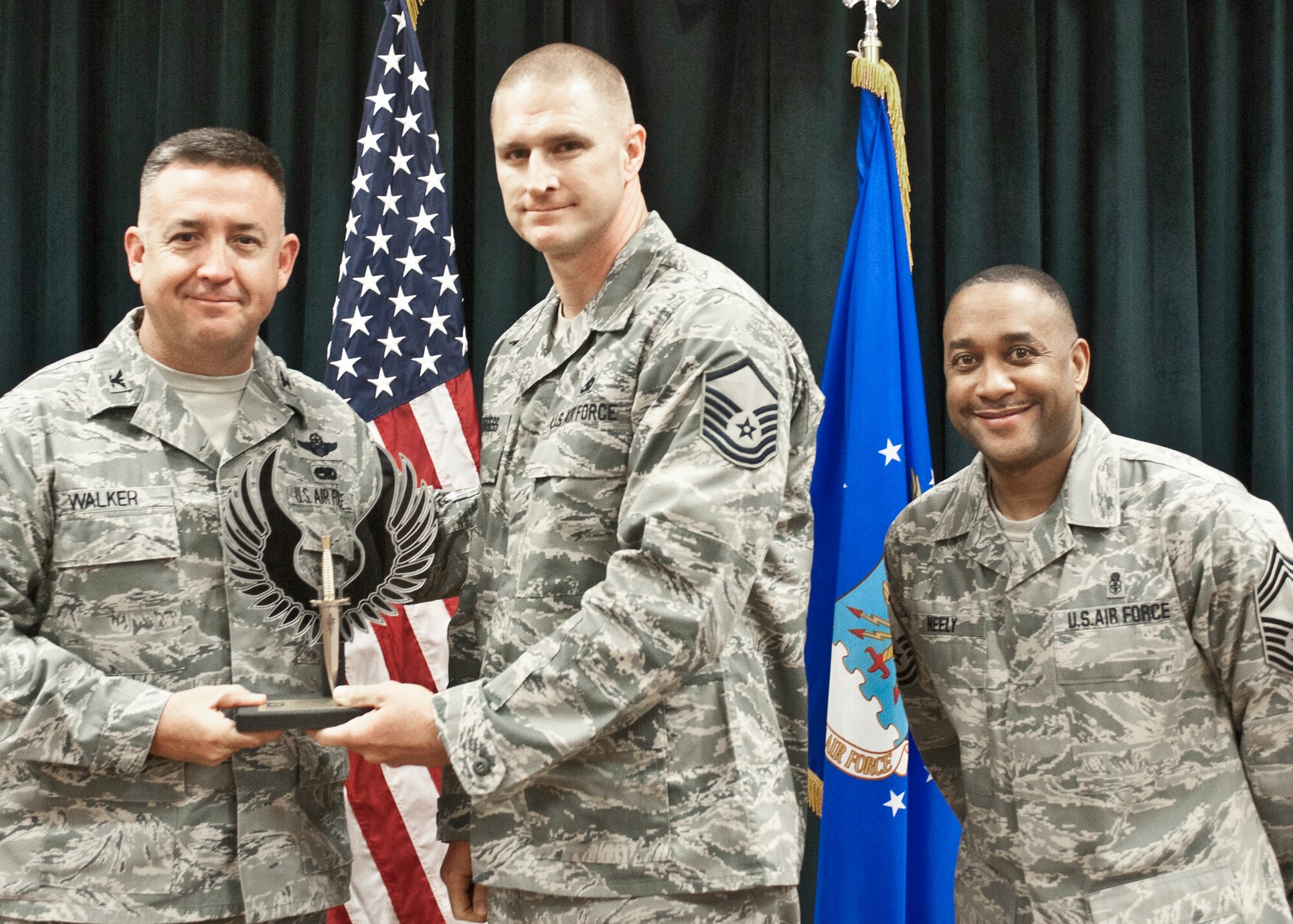 Colonel Craig Walker 27th Special Operations Wing Vice Commander, along with Chief Master Sergeant Marvin Neely present Master Sgt. Matthew Burgess with the 2013 Senior NCO of the Quarter award for first quarter April 26. Winners were selected based on outstanding accomplishments during the months of January through March. (U.S. Air Force photo/ Airman 1st Class Xavier Lockley)