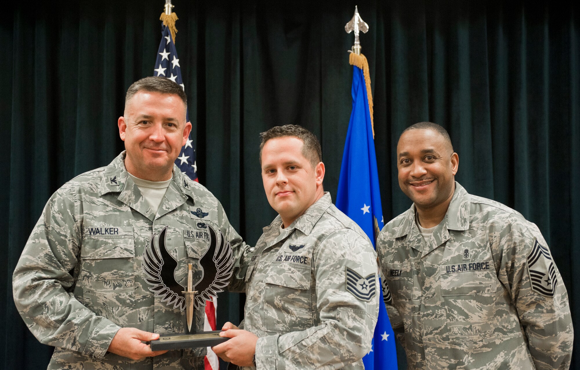 Colonel Craig Walker 27th Special Operations Wing Vice Commander, along with Chief Master Sergeant Marvin Neely present Tech. Sgt. Matthew Colbert with the 2013 NCO of the Quarter award for first quarter April 26. Winners were selected based on outstanding accomplishments during the months of January through March. (U.S. Air Force photo/ Airman 1st Class Xavier Lockley)