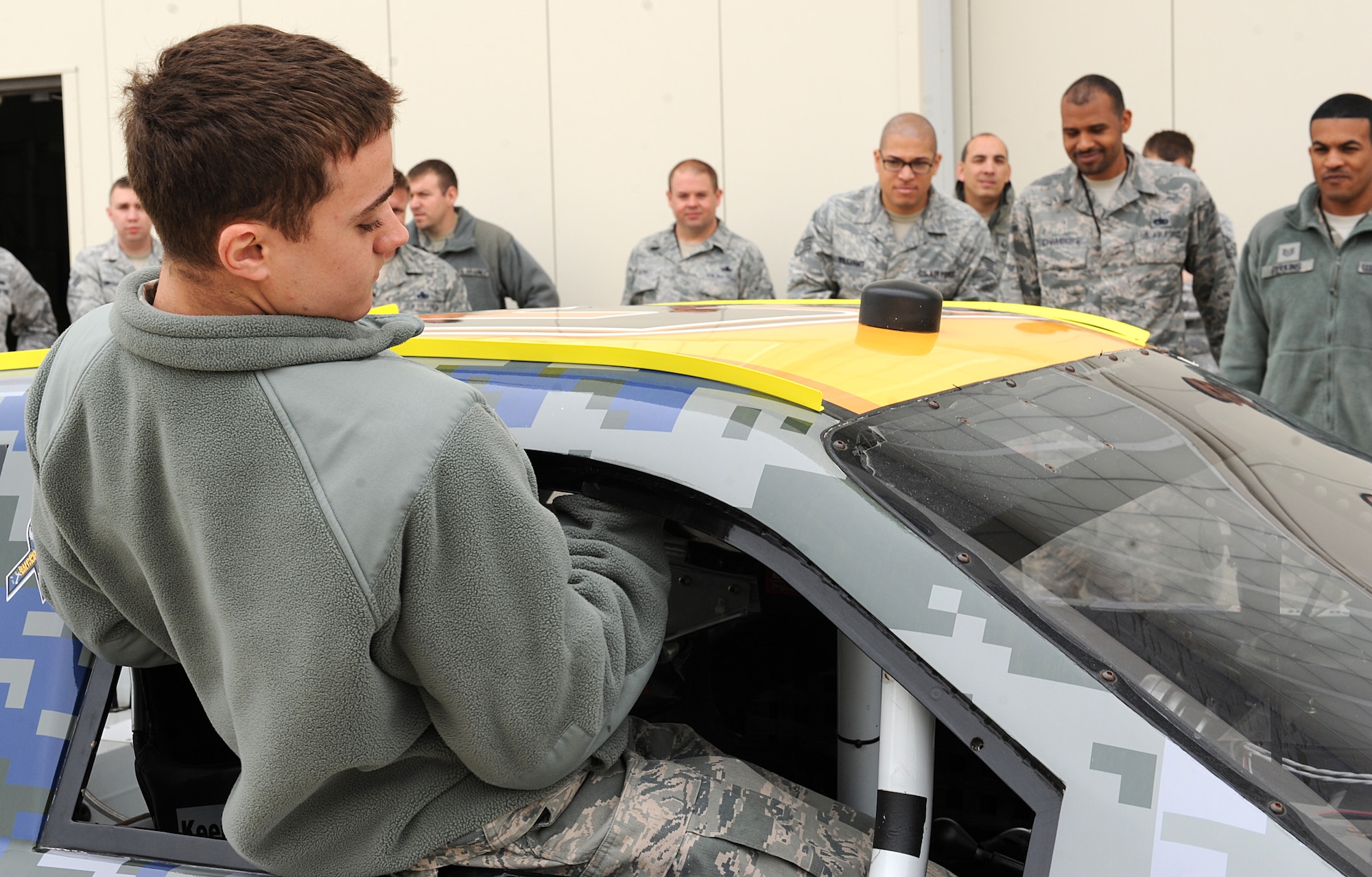 Airman 1st Class Joshua Woods, 1st Maintenance Squadron weapons technician, climbs into the number 52 former NASCAR competition vehicle at Langley Air Force Base, Va., April 24, 2013. Airmen also had a chance to look under the hood and learn about the mechanics behind a NASCAR vehicle. (U.S. Air Force photo by Airman 1st Class Kimberly Nagle/Released)