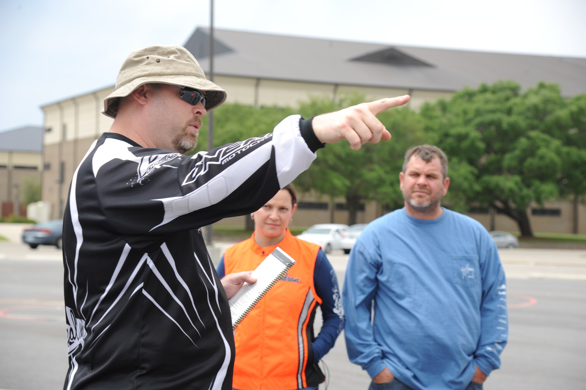 Randy Logan, 338th Training Squadron and motorcycle safety course instructor, points out the boundaries of the motorcycle driving course to Tech. Sgt. Tiffany Taylor, 81st Inpatient Operation Squadron, and her husband, Jon Olsen, during a motorcycle safety course April 18, 2013, at Keesler Air Force Base, Miss.  The course is offered twice a month and teaches students the basic operating skills and safety rules for riding a motorcycle on the road.  (U.S. Air Force photo by Kemberly Groue)