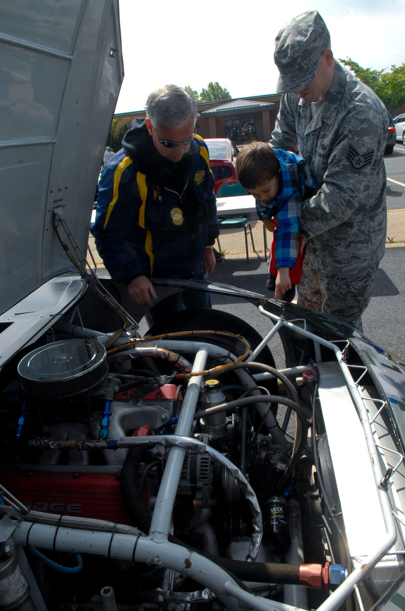 U.S. Air Force Staff Sgt. Sean Cartwright, 83rd Network Operations Squadron network operations technician, and his son, Nathan, ask questions about a NASCAR competition vehicle April 24, 2013, at Langley Air Force Base, Va. The number 52 car visited Joint Base Langley-Eustis to support Service member morale. (U.S. Air Force photo by Airman 1st Class Austin Harvill/Released)
