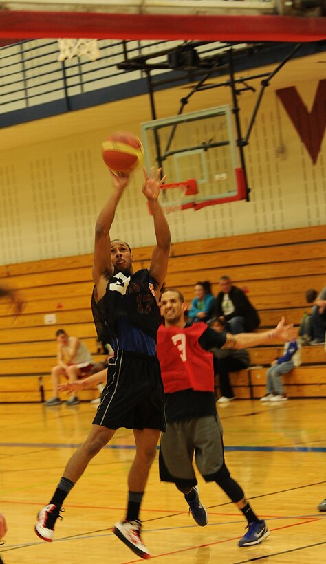 Airman 1st Class Michael Bryant, 28th Aircraft Maintenance Squadron weapons loader, takes a jump shot during the base 2013 Intramural Basketball League championship game in the Bellamy Fitness Center at Ellsworth Air Force Base, S.D., April 24, 2013. During April, all 10 teams in the league faced off against each other in the playoffs, and the 28th AMXS and 28th Security Forces Squadron emerged as the two teams competing in the final game. (U.S. Air Force photo by Airman 1st Class Hrair H. Palyan/Released)