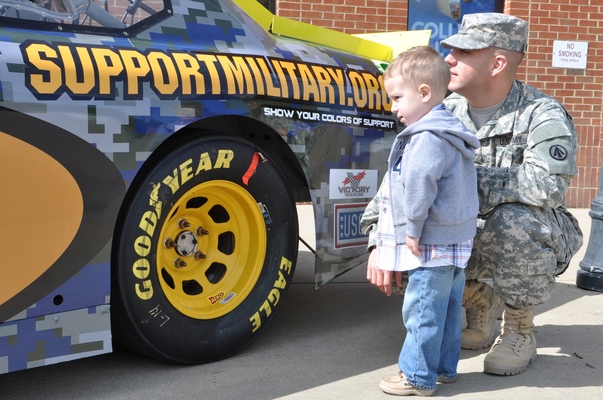 Staff Sgt. Matthew Williamson, 597th Transportation Brigade human resources noncommissioned officer, and his son Westyn view a NASCAR show car at Fort Eustis, Va., April 4, 2013. The display aimed to build Soldier morale and promote SupportMilitary.org. The Support Military mission is to link America to verified organizations that provide needed support to active duty, National Guard, reserve, veterans and their families. (U.S. Air Force photo by Tech. Sgt. April Wickes/Released) 