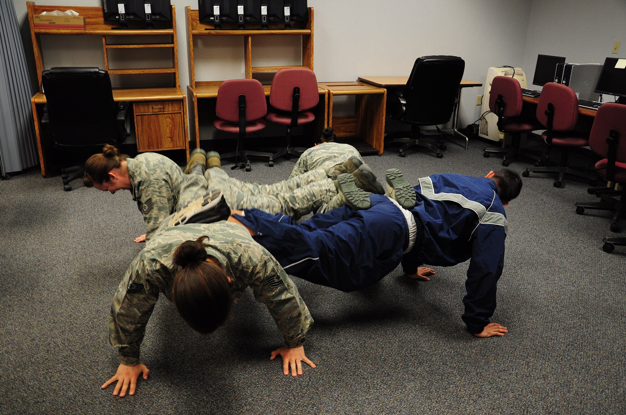 WRIGHT-PATTERSON AIR FORCE BASE, Ohio - 445th Maintenance Operations Squadron reservists Tech. Sgts. Cassandra Bartlett, Ashley Dahl, Kara Lamm and Senior Airman Don Knight do the four-man push-up as an activity to represent the physical fitness pillar and teamwork during the 445 MOS Wingman Day April 7. (U.S. Air Force photo/Airman 1st Class Santana Austin)
