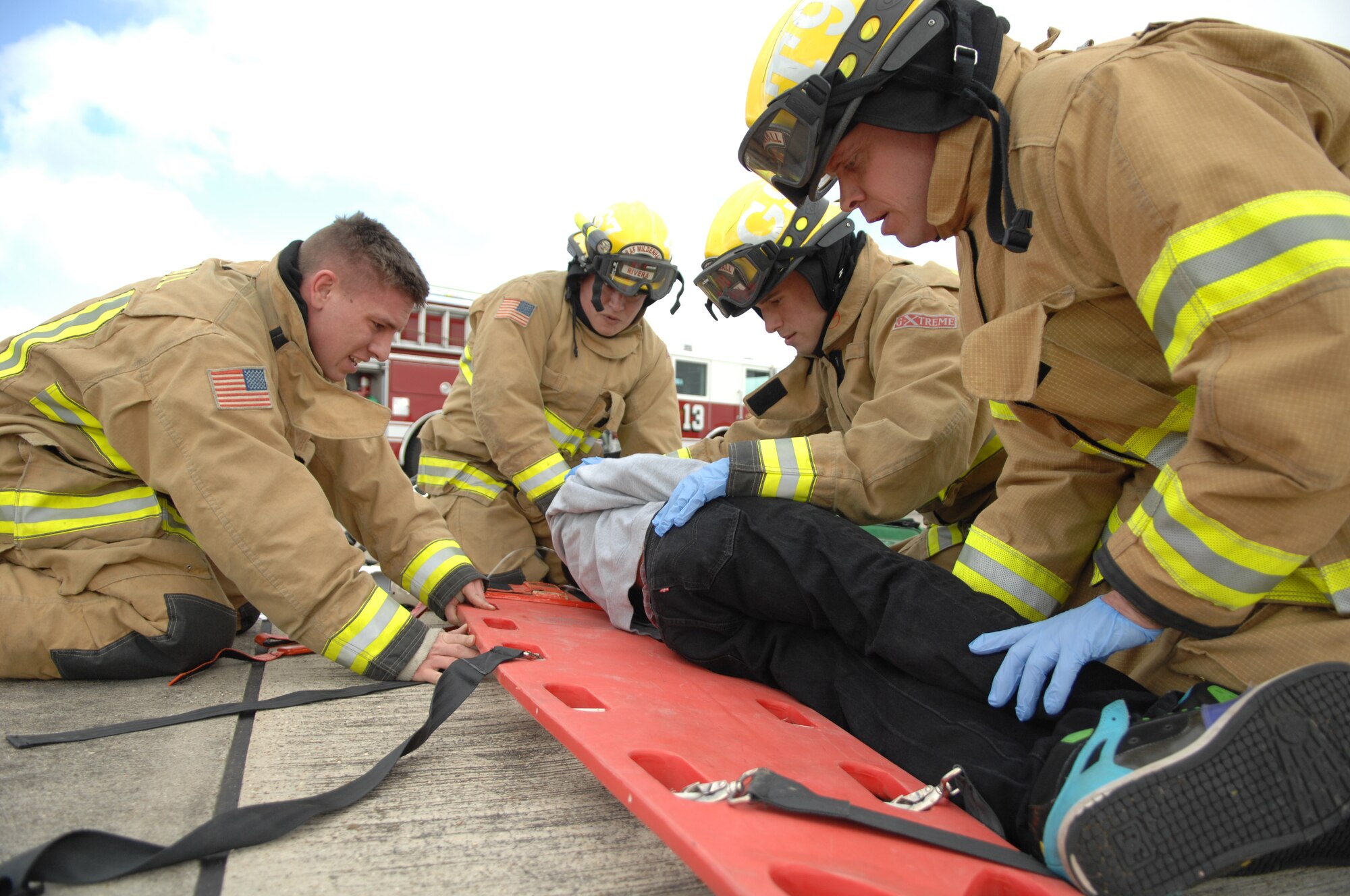 Firefighters from the 100th Civil Engineer Squadron roll a “casualty” onto a litter during an exercise April 29, 2013, on RAF Mildenhall, England. Firefighters and medical personnel worked to rescue and treat simulated casualties that resulted from a KC-135 Stratotanker “landing gear failure” during the exercise. [(Editor’s note: This image is from an exercise and does not depict any real world event.)(U.S. Air Force photo by Airman 1st Class Dillon Johnston/Released)]