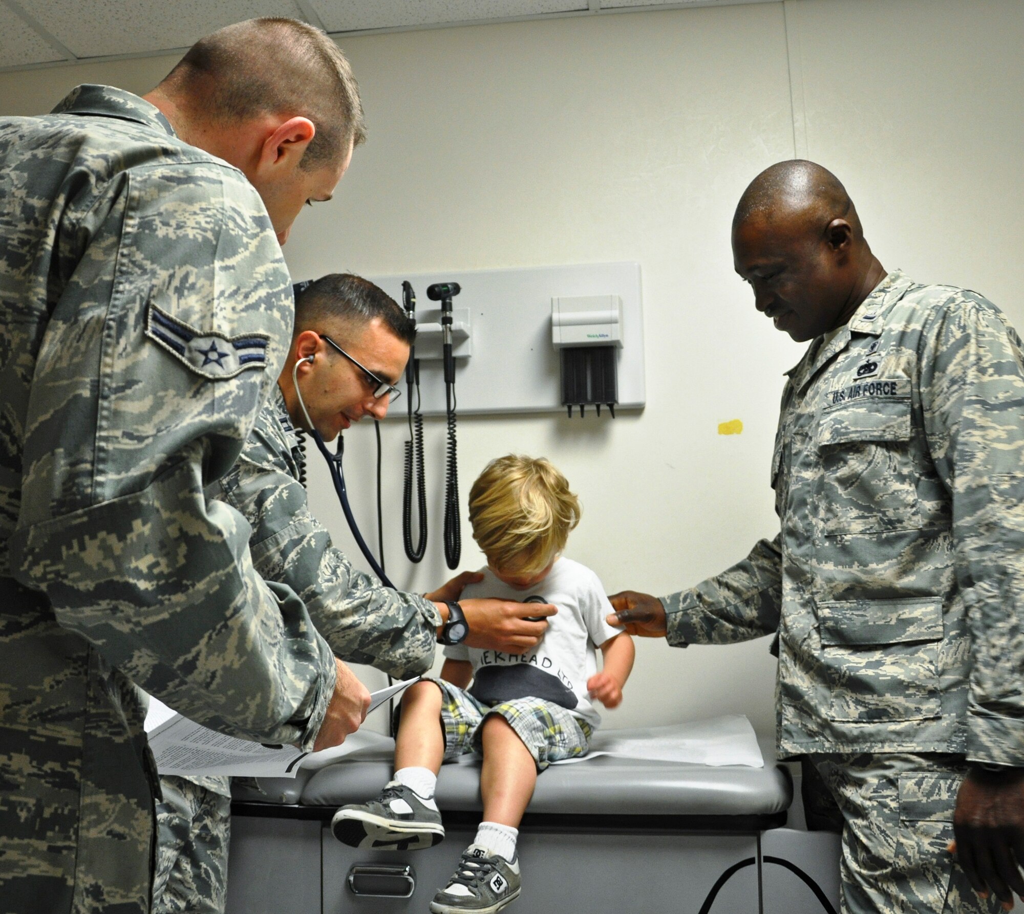 Capt. Justin Manganaro and his pediatric PCMH team treat a child in the Pediatrics Clinic. PCMH is a new model of care where a patient has one primary provider alongside a team of health professionals. The providers work together to provide structured care based around the patient's medical needs and focused on the whole person. (U.S. Air Force photo/Tech. Sgt. Crystal Turner)

