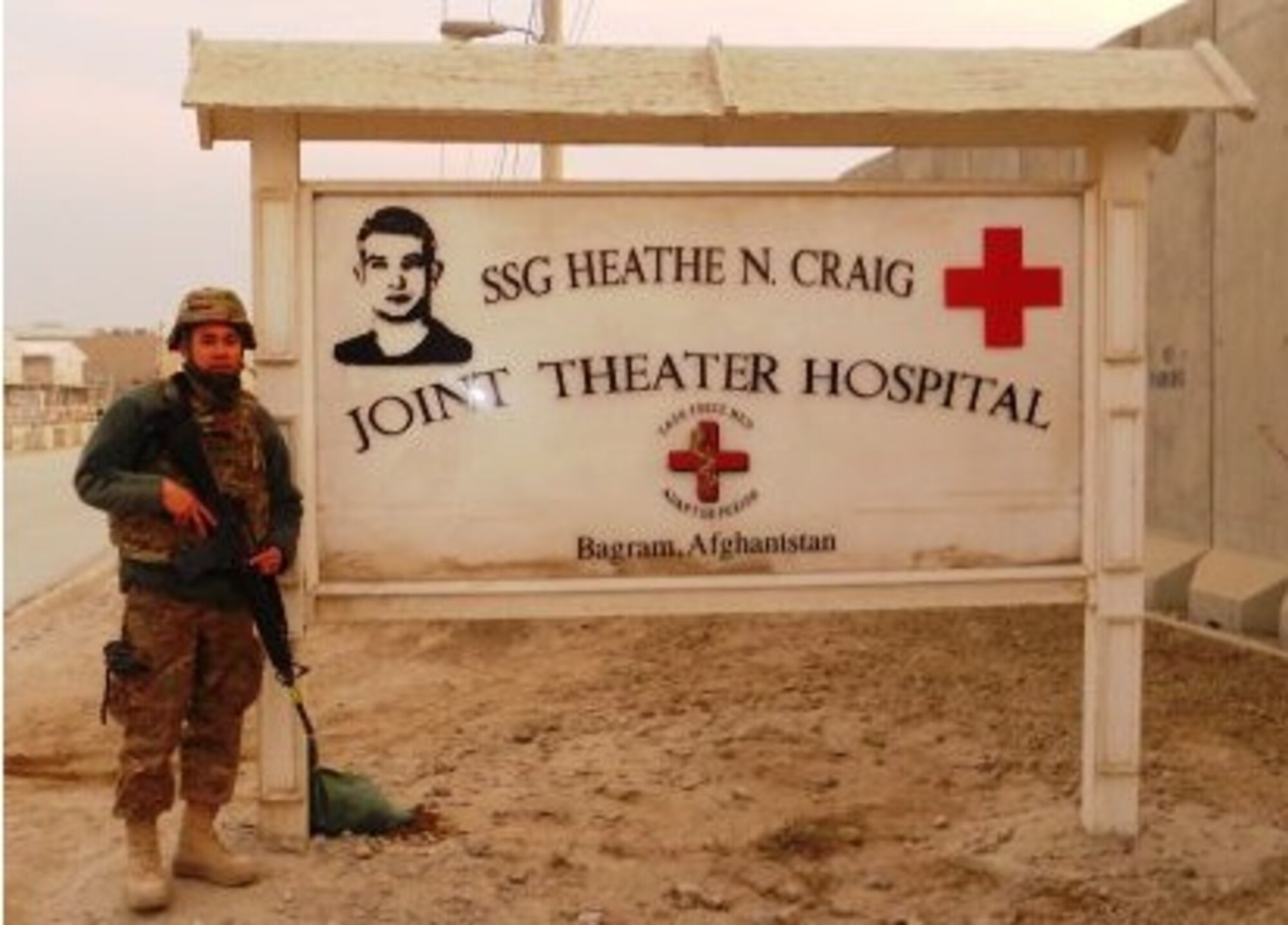 Staff Sgt. Angelo Mejia, 6th Aeromedical Squadron bioenvironmental engineering technician, stands next to the hospital identification sign in his deployed location in this undated photo. (courtesy photo/released)